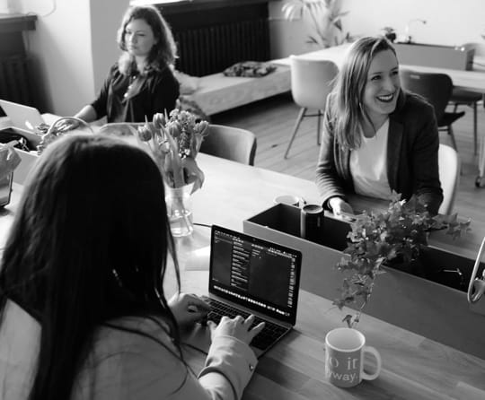 Three women working in an open office